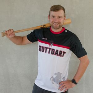 Mann präsentiert das schwarz-rot-weiße Gewinnertrikot des TVC Fantrikot Battles 2026
